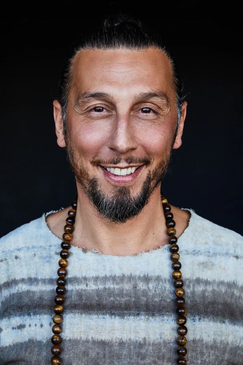 Ali während seiner spirituellen Reise von 2019 bis 2024, mit zurückgebundenen Haaren und einer Perlenkette.