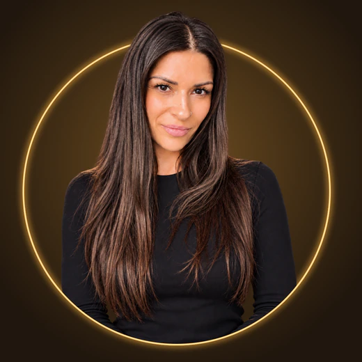 Derya mit langem dunklem Haar vor einem goldenen Ring